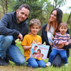 Familia disfrutando de su tiempo al aire libre y de su libro personalizado para familias.