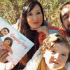 Familias felices disfrutando de su libro familiar personalizado, que es un excelente regalo de Navidad.