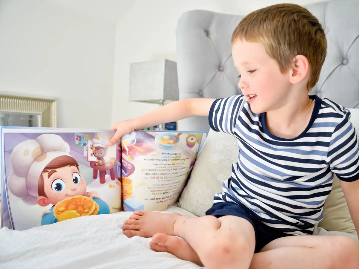 Un niño mirando un libro personalizado para padres y su hijo.