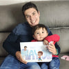 Hombre sosteniendo amorosamente a su pequeño hijo y a su perro leyendo un libro emocional sobre qué será su hijo cuando crezca.