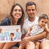 Familia sonriente descubriendo el Libro Personalizado para Papá hecho a medida justo para papá y su hijo.