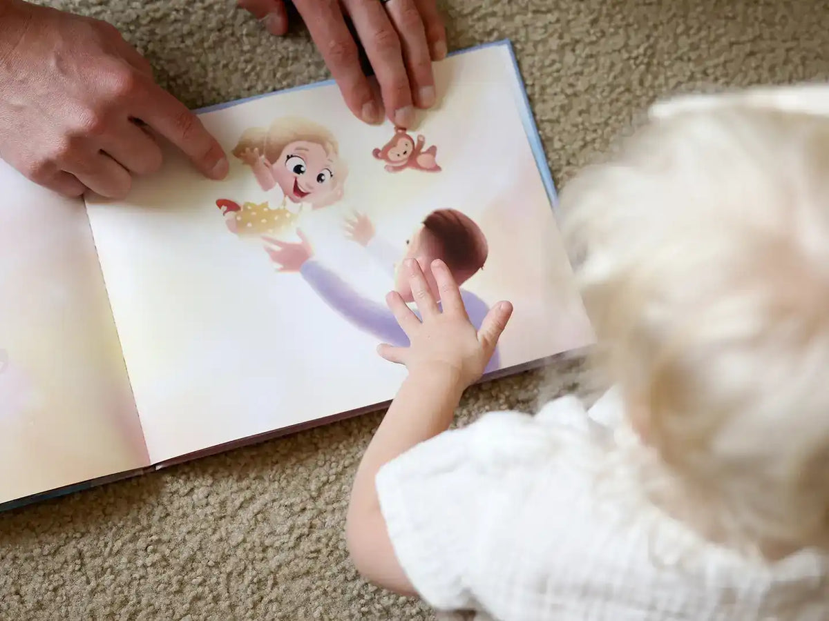 Un bebé mira una ilustración de un libro personalizado para padres.