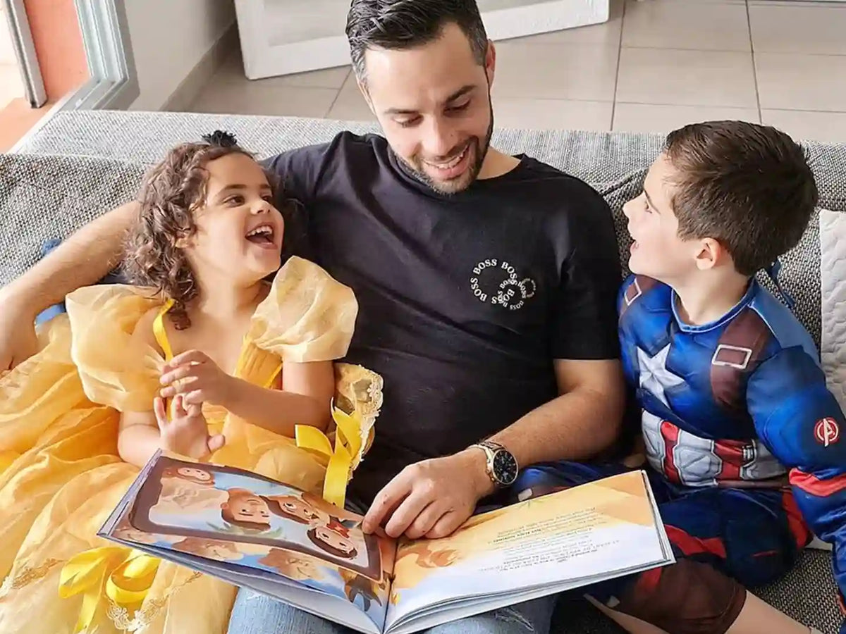 Familia sonriente descubriendo el Libro Personalizado para Papá hecho a medida justo para papá y sus hijos.