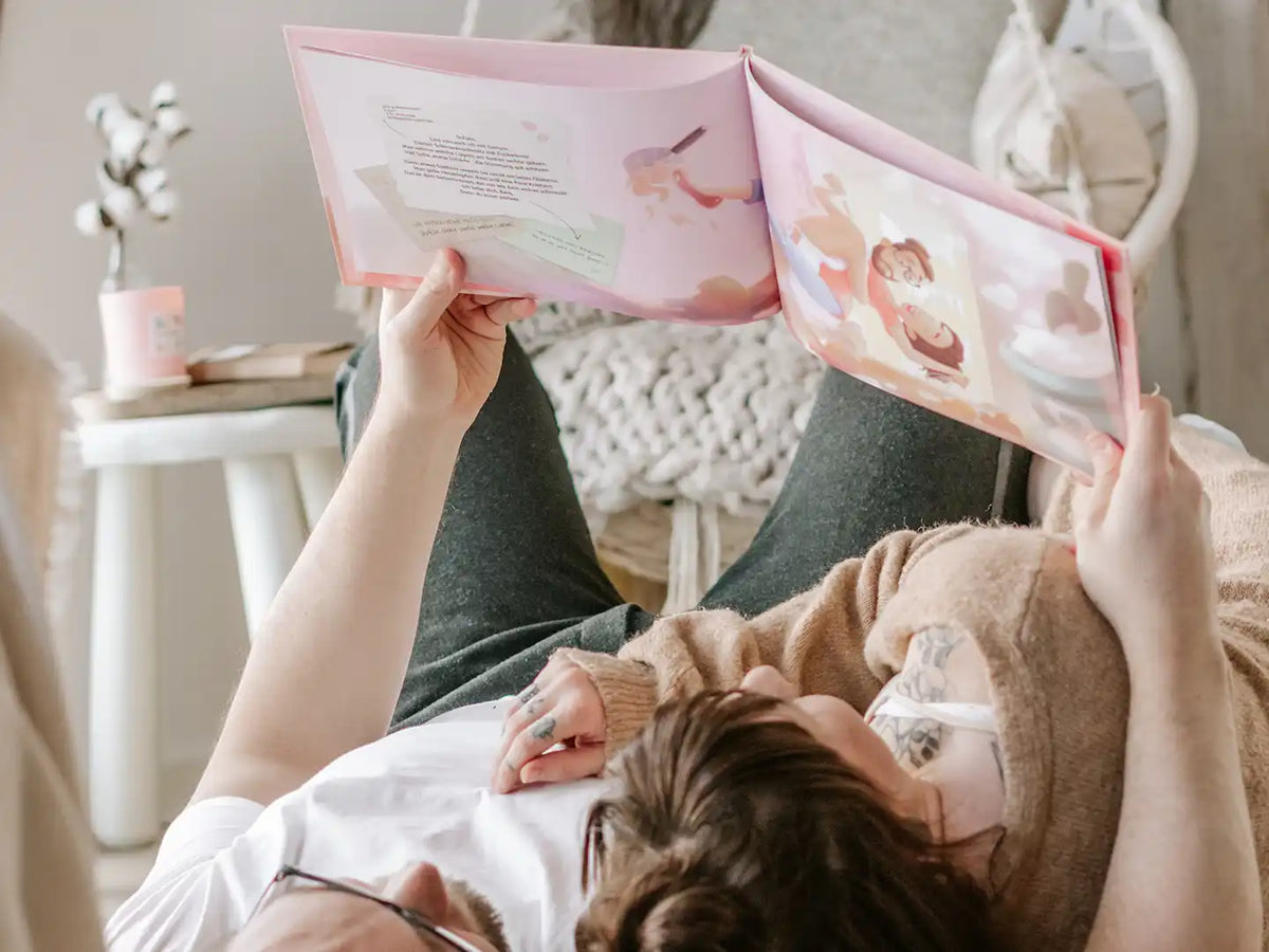 Novia y novio tirados en el suelo pensando en el gran regalo de libro personalizado que recibieron para su aniversario.